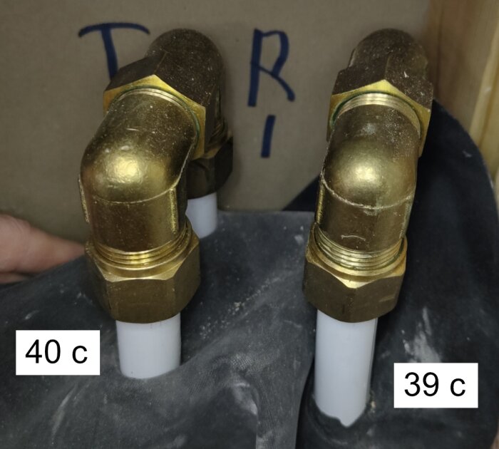 Bild på två kopparrörs-böjar anslutna till vita rör, märkta med temperaturerna 40 c och 39 c.