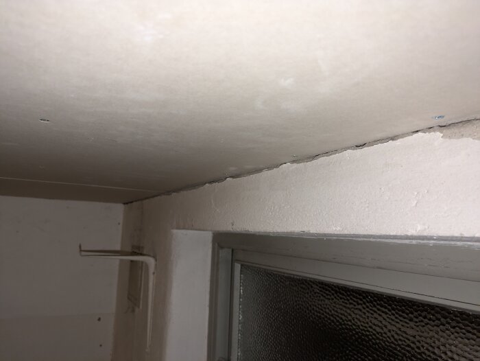 Gap between wall and ceiling near a window, with a discussion about using filler or plaster for sealing.