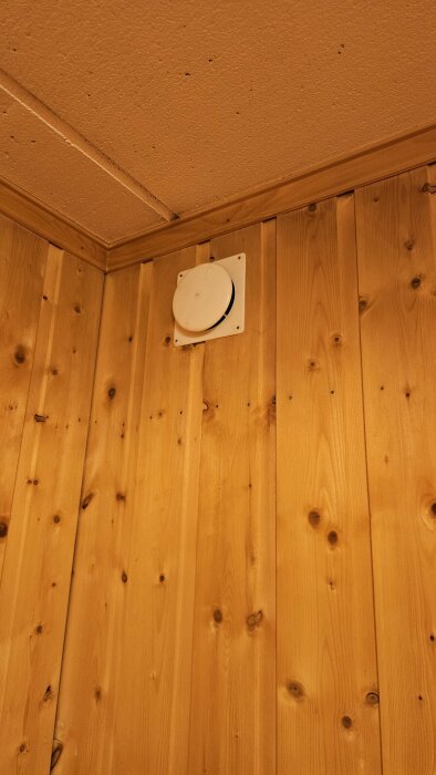 Ventilationsöppning i trävägg vid taket, del av ett projekt för att montera nytt kök och hantera ventilation från bastu och dusch i källare.