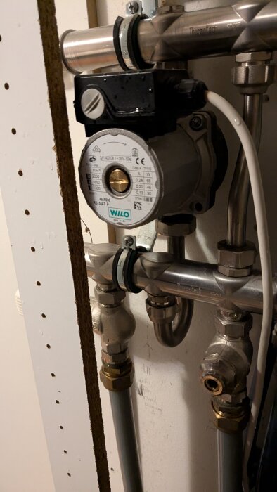 Bild på del av rörsystem med en monterad Wilo-pump, omgiven av ventiler och metallrör.