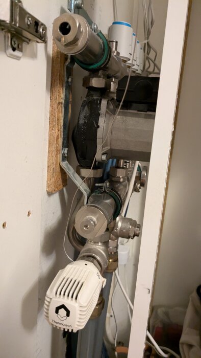 Närbild av rörsystem med avstängningsventiler och Thermotech-regulator i samband med förberedelse för pumpbyte.