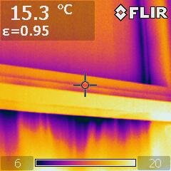 Termografibild av fönster, visar temperaturfördelning och potentiell värmeläckage med kall luft runt ramen. Temperatur 15,3°C, emissivitet 0,95.