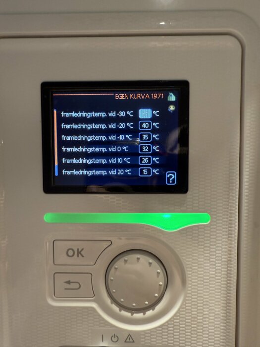 Närbild på en värmepumpskontrollpanel med inställningar för framledningstemperatur vid olika utetemperaturer, inklusive justeringsknappar.