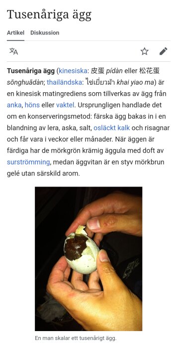 En person skalar ett tusenårigt ägg med mörkbrun äggvita och grönaktig äggula.