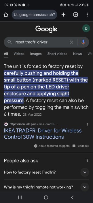 Google-sökning på "reset tradfri driver" visas på en mobiltelefons skärm, instruktioner för fabriksåterställning markerade med blått.