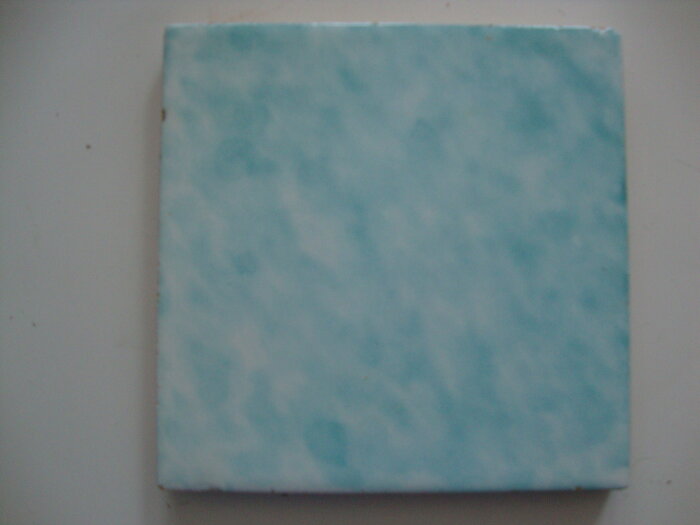 Turkos kakelplatta med melerade mönster.