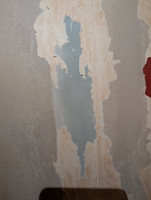 Avskalad tapet avslöjar oregelbunden ljusgrön fläck på vägg i ett trähus. Möjligen grön mögel, osäker bedömning söks av husägare.