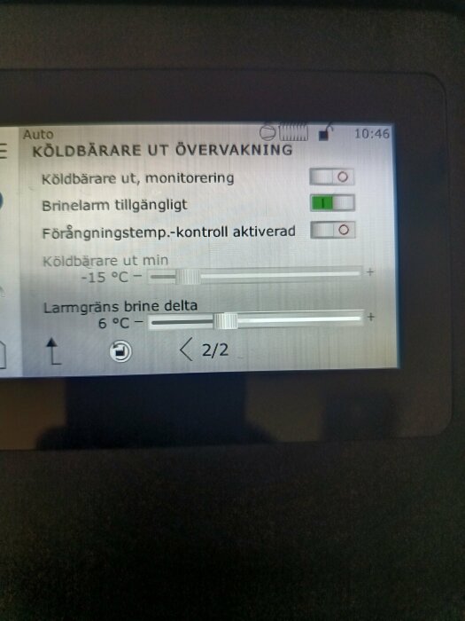 Display på övervakningssystem för köldbärare med temperaturinställningar och brinelarm, tid ställd på 10:46.