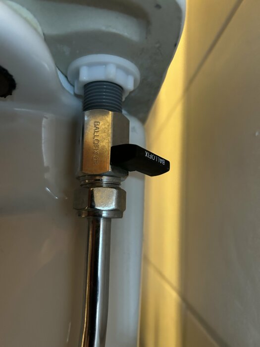 Grå plastgänga på inloppsventil och Ballofix-ventil under toalettcistern.