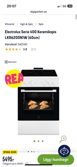 Vit Electrolux Serie 400 keramisk spis med fyra kokplattor, öppnad ugn med croissanter, med "REA"-etikett och pris 5495 kr på Elgiganten.