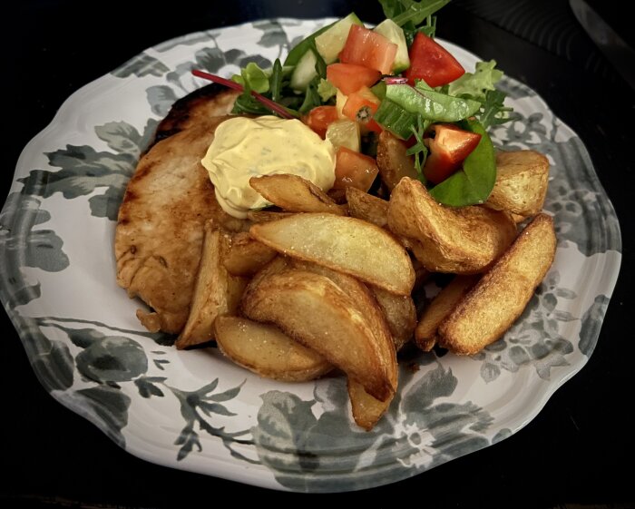 Tunna fläskkotletter med klyftpotatis, sallad med mango och en klick chipotelbea på tallrik.