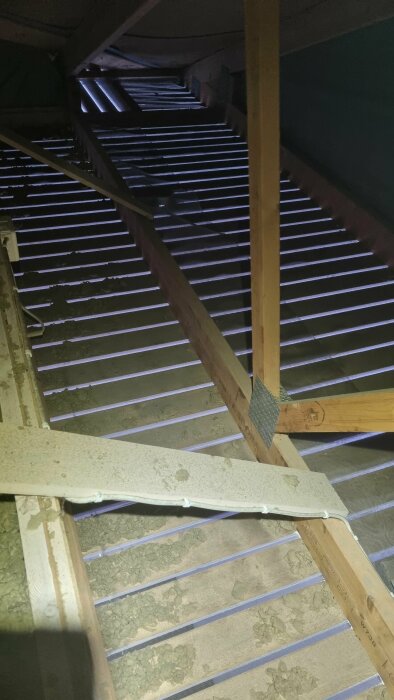 Vind med synliga springor och träkonstruktioner, där ljus tränger in. Behov av tätning för att minska fuktighet diskuteras i inlägget.