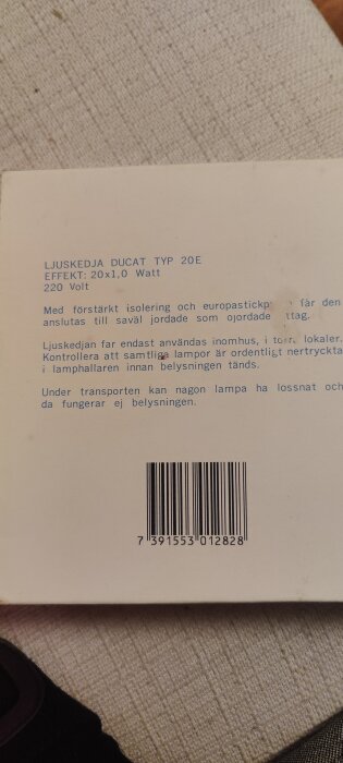 Text på baksidan av en förpackning för ljuskedja Ducat typ 20E med specifikationer och instruktioner för användning. Streckkod längst ner.