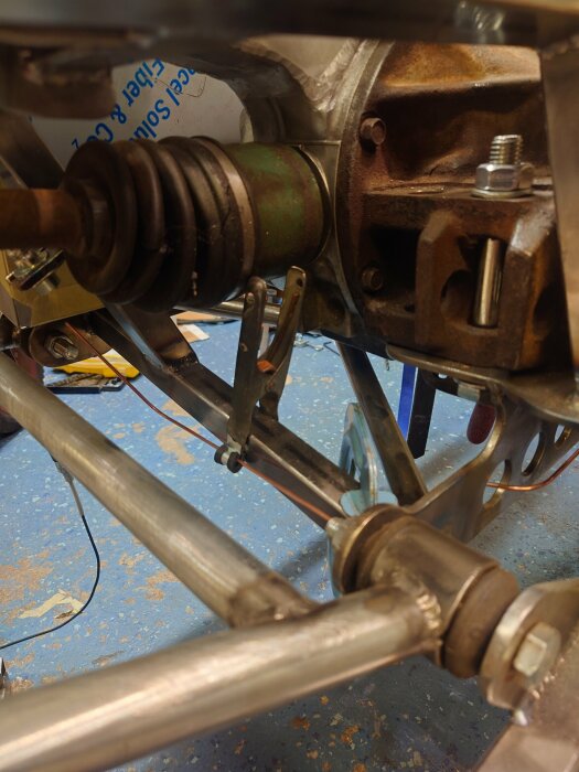 Ett närbildsfoto av underredet på ett fordon med fokus på metallrör, leder och delar kopplat till en bränsletrycksregulator.