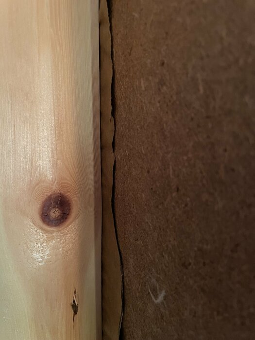 Närbild av träregel intill en brun ångbroms med oregelbunden kant, ses i sammanhang av att sammanfoga ny och gammal byggstruktur.