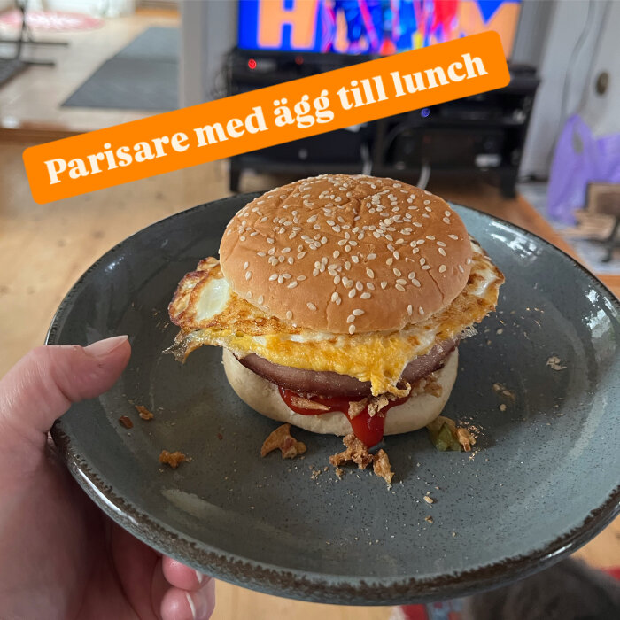 Parisare med stekt ägg serverad på tallrik; innehåller ketschup, senap, bostongurka och rostad lök.