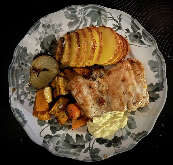 Stekt kycklinglårfilé med ugnstekta grönsaker, hasselbackspotatis och bearnaisesås på en blommig tallrik.
