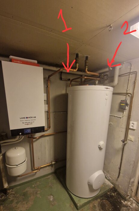 Vattenbehållare med rör och värmeinstallation, markeringar för vattenpåfyllning och bildplats visas med röda pilar.