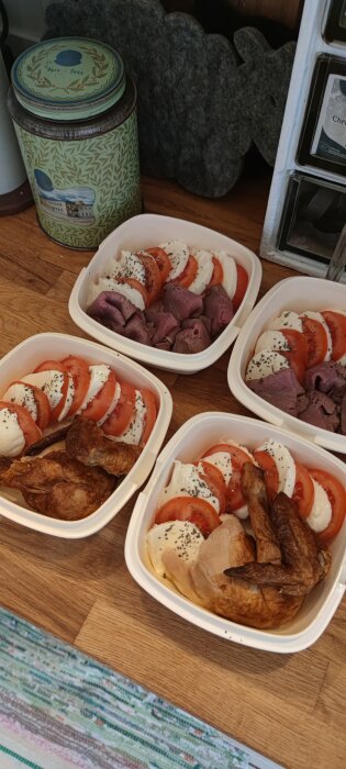 Fyra matlådor med mozzarella, tomater, rostbiff och kyckling på en köksbänk.