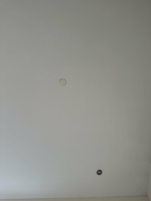 Spricka i vitt gipstak med två infällda lampor.