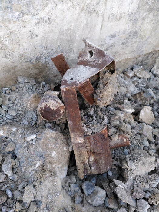 Rostig metallbit och betongrester på marken, beskriven som "lokomotivet" i inlägget.