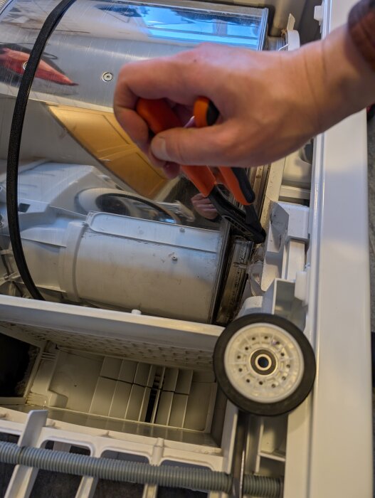 Hand som använder en polygrip på en Cylinda TK 300 med remmen runt trumman. Maskinen ligger på sidan för att underlätta arbetet.