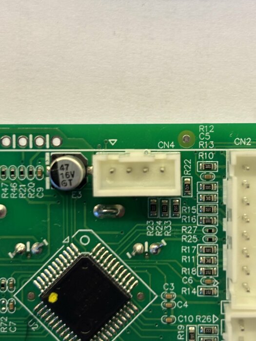 Bild av ett kretskort där CN4-markeringen syns nära mittkonsolen och flera elektroniska komponenter är placerade runtom.