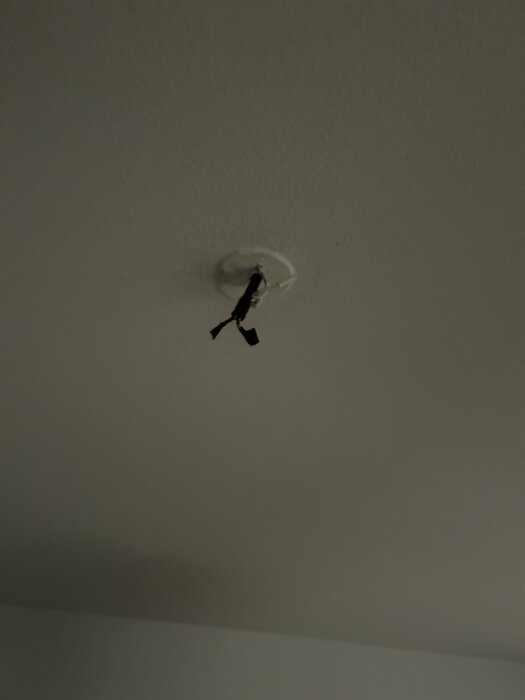 Tak med sladdar som hänger ut ur ett hål, redo för montering av taklampa i ett äldre hus utan DCL-uttag.