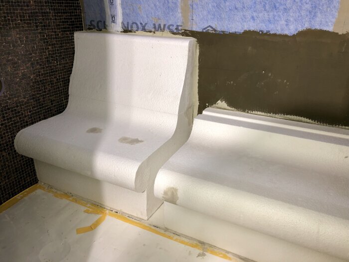 Vita gipsskivor formade som bänkar i ett byggprojekt, del av renovering 2019.