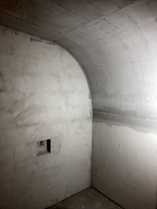 Betongväggar och tak i ett byggprojekt med en inbyggd nisch, visar byggnadernas råa ytor från 2019.