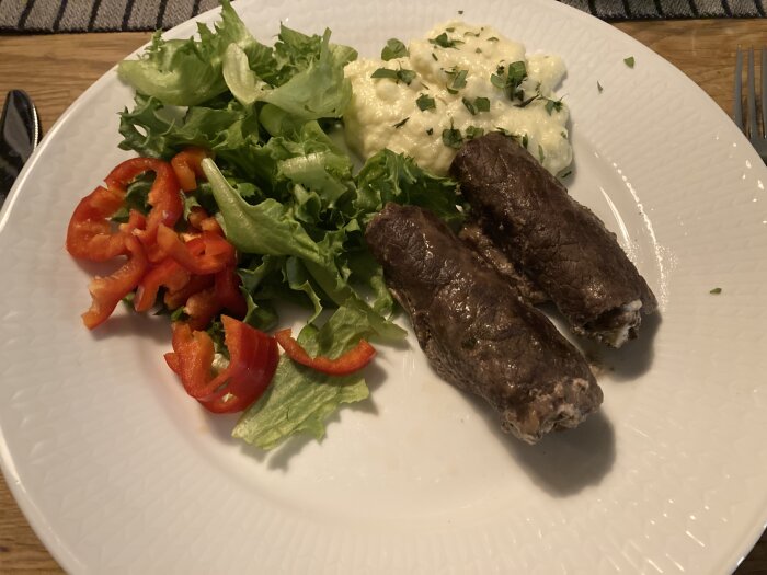 Lövbiff fylld med senap och Philadelphiaost, serverad med blomkålsmos och sallad på en tallrik.