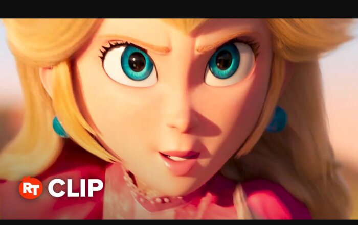 Animerad karaktär med stora blå ögon och blont hår i närbild, bär rosa kläder och blåa örhängen.