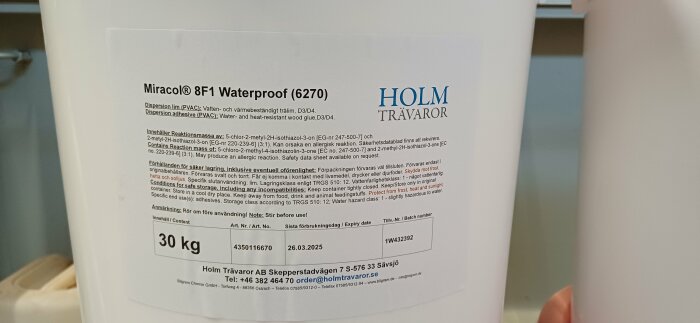 Behållare med Miracol 8F1 Waterproof lim från Holm Trävaror, 30 kg, för träarbeten. Innehåller detaljerad säkerhetsinformation och hållbarhetsdatum.