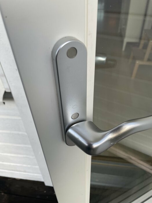 Altandörr med silvrigt handtag och enkelt lås, sedd inifrån med önskemål om att installera ett lås som kan öppnas med nyckel utifrån.