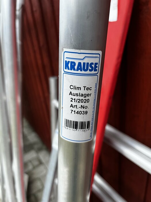 Aluminiumrör med Krause-märkning, del av byggställning Clim Tec, på stenlagt underlag.