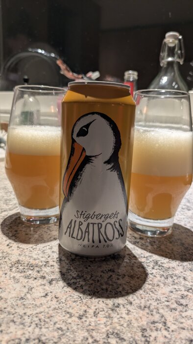 Burk Stigbergets Albatross NEIPA öl mellan två glas på bord.