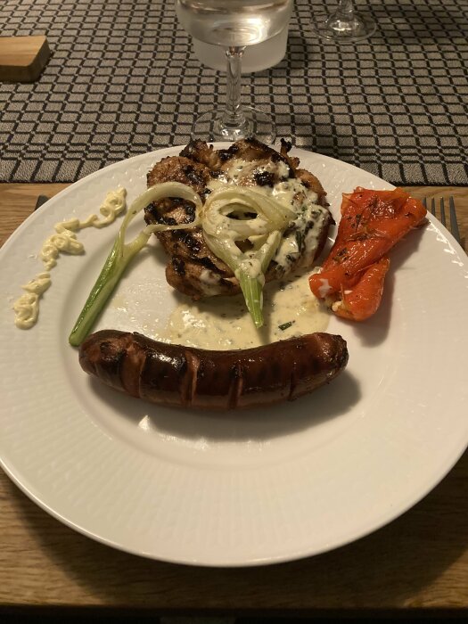 Honungs- och Smokey-marinerad kyckling med fänkål, paprika, korv och ädelostsås på en tallrik.