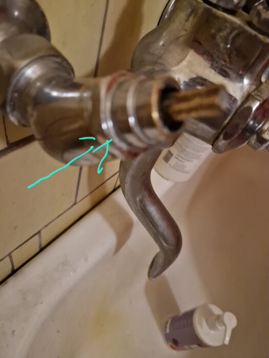 Kranarmatur i kök med borttaget vred, blå pil pekar mot mutterformad del. Vattenpåslag nämns i textdiskussion.