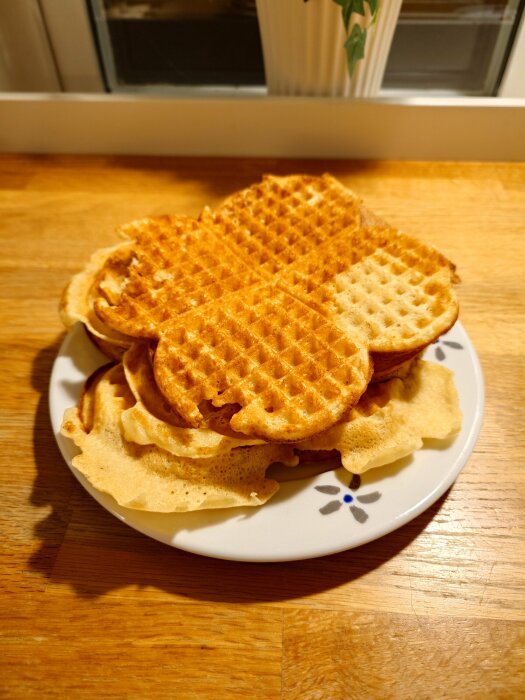 Tallrik med nygräddade våfflor på ett bord.