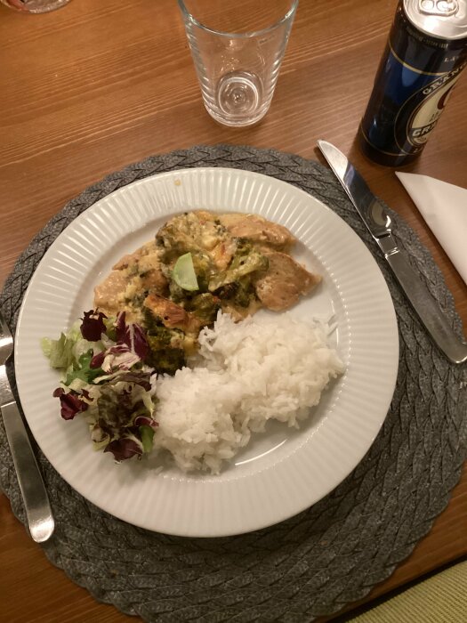 Tallrik med kyckling, broccoli och ädelostgratäng, ris och sallad.