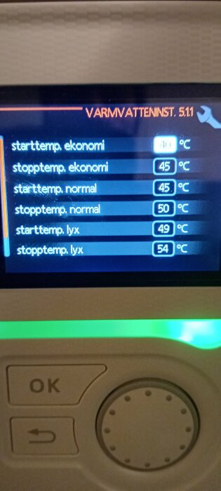 Display på värmepump med olika varmvatteninställningar som "starttemp ekonomi" vid 40°C och "stopptemp lyx" vid 54°C.