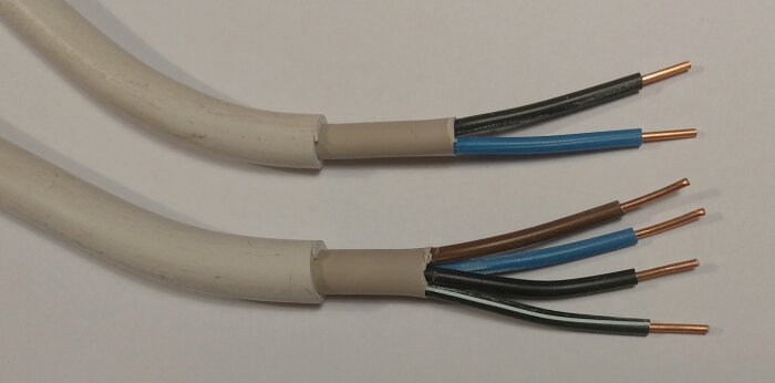 Två avskalade elektriska kablar med exponerade kopparledare.