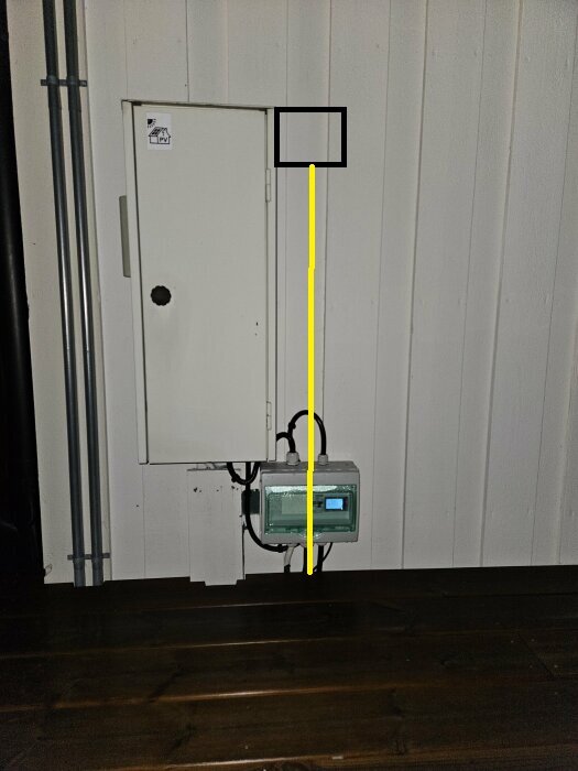 Elskåp på yttervägg med kabeldragning till en kapsling under, monterat i ett utsatt läge.