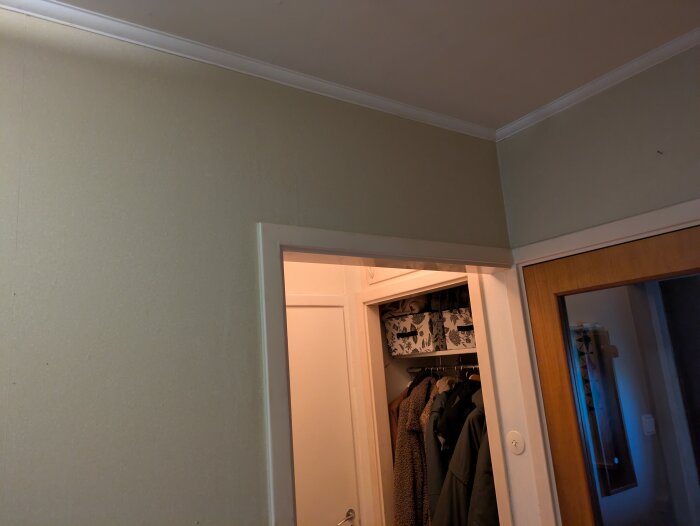 Liten hall från 60-talet med en icke-bärande vägg och klädkammare, funderingar kring renovering för mer ljus och rymd.