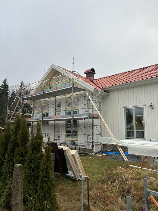 Husrenovering med byggnadsställningar, fönsterbyte och arbeten på tak och fasad.