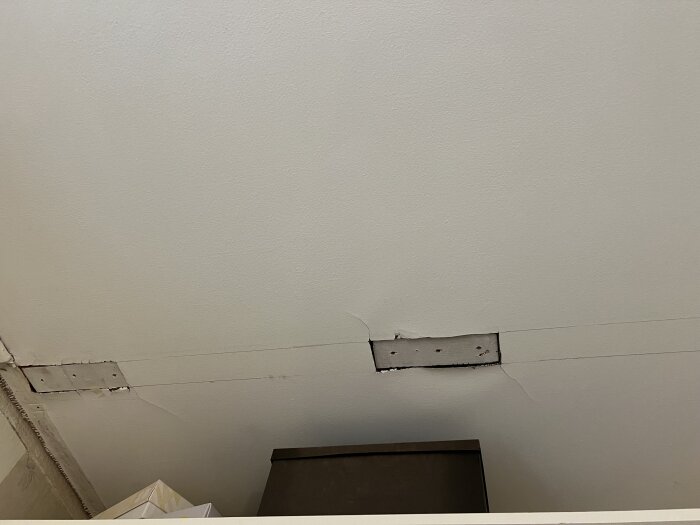 Hål i vävtak efter borttagen garderob, visar nakna reglar och utskuren väv.