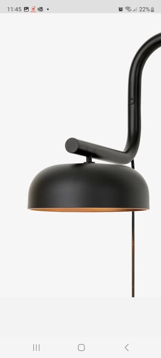 Svart modern lampskärm med metallarm, brytare synlig. Minimalistisk design mot vit bakgrund.