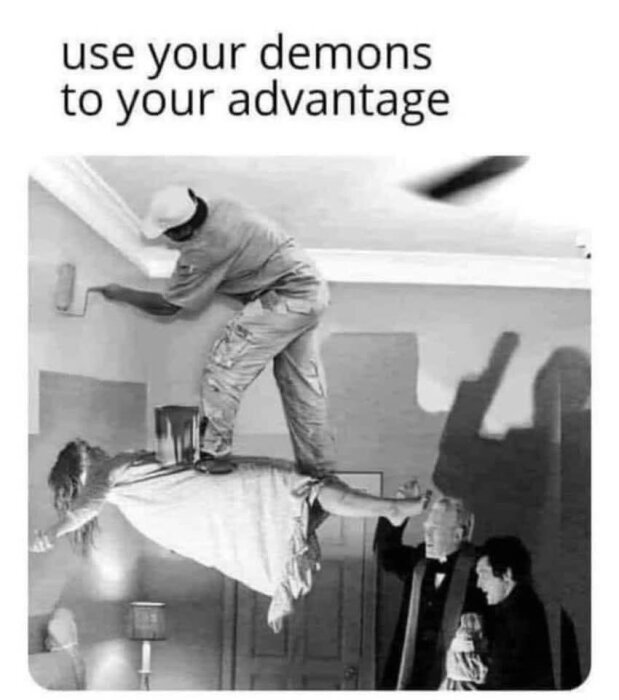 En man målar ett tak medan han står på en svävande person. Texten ovanför säger "use your demons to your advantage". Vintage svartvit bild.