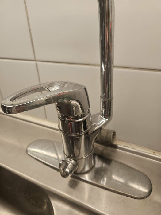 Köksblandare med vattenanslutning, potentiell plats för diskmaskininstallation.