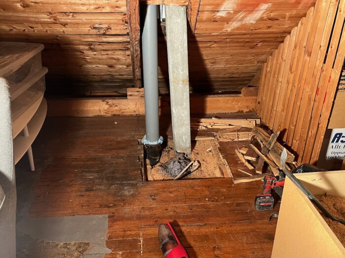 Vind med synliga ventilationstrummor, höger i bild är duschens. Del av golv öppet med byggskräp; materialet ser eternitliknande ut.